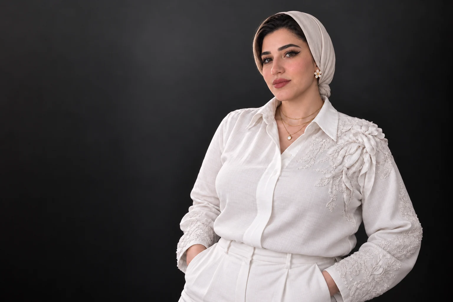 Rana Kandil wearing an embroidered white blouse and a grey headscarf